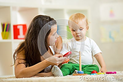 Cute mother and baby boy play together indoor at Stock Photo