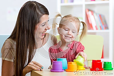 Cute mother and child daughter playing educational toys indoor Stock Photo