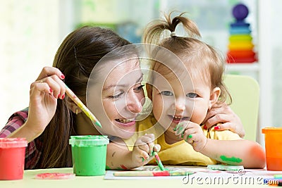 Cute mother teach her daughter kid to paint Stock Photo