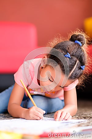 Cute multiracial small girl drawing on a coloring book Stock Photo