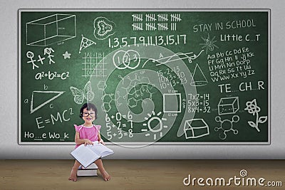 Cute nerd girl reading book in class Stock Photo