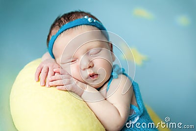 Cute newborn baby sleeping on a moon pillow Stock Photo