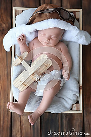 Cute newborn baby wearing aviator hat in crate, top view Stock Photo