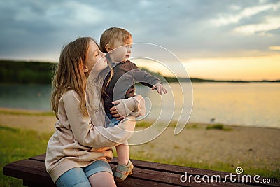 Cute older sister cuddling with her toddler brother. Adorable girl holding baby boy. Children with large age gap Stock Photo