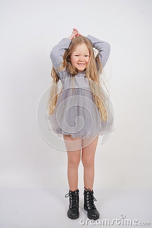 Cute orphan girl stands and holds her hands over her head in the form of a house, dreaming of an apartment, on a white background Stock Photo