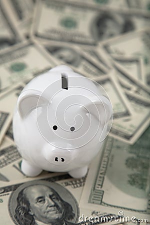 Cute Piggy Bank on heaps of cash Stock Photo