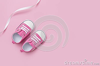 Cute pink baby girl sneakers close up on pink background Stock Photo