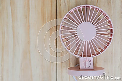 Pink portable USB fan on wooden frame for cool temperature Stock Photo