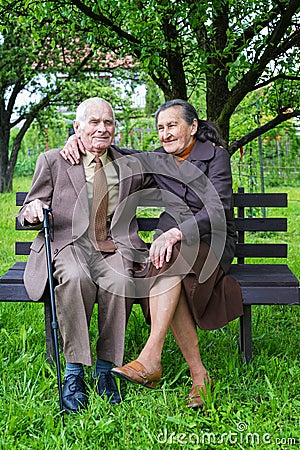 Cute 80 plus year old married couple posing for a portrait in their garden. Love forever concept Stock Photo