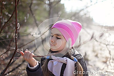 Cute preschool girl smelling and gather pussy willows Stock Photo