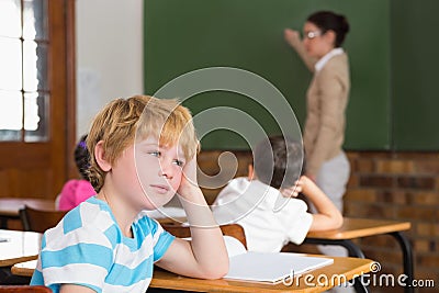 Cute pupil not paying attention in classroom Stock Photo