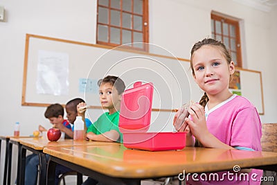 Cute pupils having their lunch in classroom Stock Photo