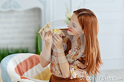 Cute red-haired girl holding ducklings and smiling, Easter Stock Photo