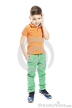 A cute school-age boy in a bright orange polo t-shirt is talking on a smartphone. Full height. Vertical. Isolated on a white Stock Photo
