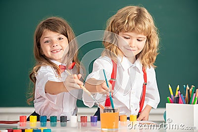 Cute school friends kids drawing and painting at school. Friendly boy an girl funny pupils draw. Friendship in school Stock Photo