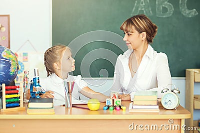 Cute schoolgirl and her teacher in a classroom Stock Photo