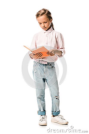 cute schoolkid holding orange book while standing on white. Stock Photo