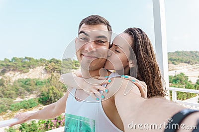 Cute selfie of a young married couple, a woman kissing the cheek of a man Stock Photo