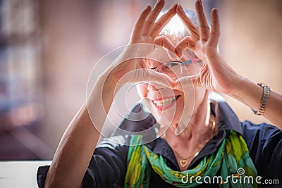 Senior woman making a heart shape, cute and lovely Stock Photo