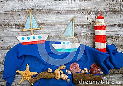 set of kids handcrafted boats, fish, nautical attributes and more on rough vintage wooden background top view Stock Photo