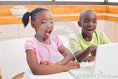 Cute siblings using laptop together Stock Photo