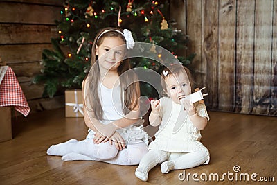 Cute sisters in front of decorated Christmas tree Stock Photo