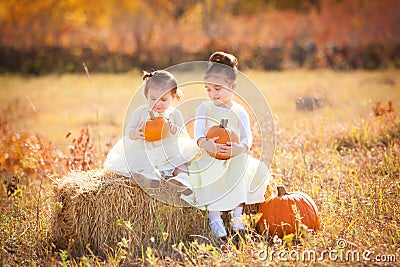 Cute sisters holding pumpkins Stock Photo