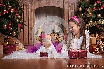 Cute sisters lying near christmas trees Stock Photo