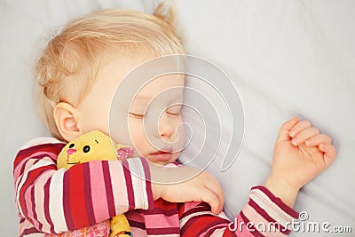 Cute sleeping blond baby with toy Stock Photo