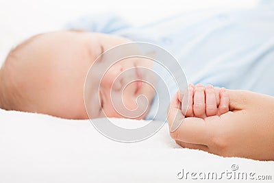 Cute sleeping newborn baby child holding mother hand Stock Photo