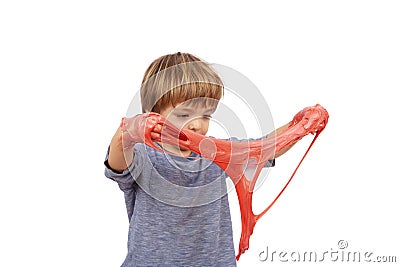 Cute small boy playing with slime looks like red gunk squeezing it between his hands Stock Photo