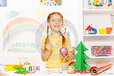 Cute small girl with brush painting New Year ball Stock Photo