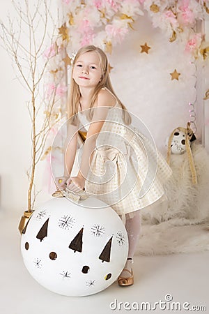 Cute smiling blondy girl with a huge Christmas ball Stock Photo