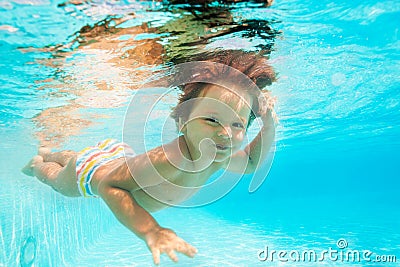 Cute smiling boy swimming under water of pool Stock Photo
