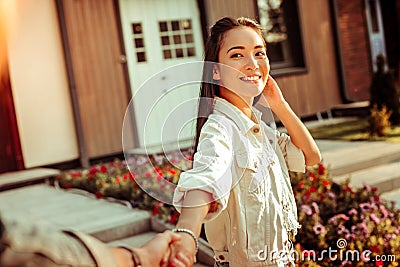 Cute smiling dark-haired girl in white jacket showing white teeth Stock Photo