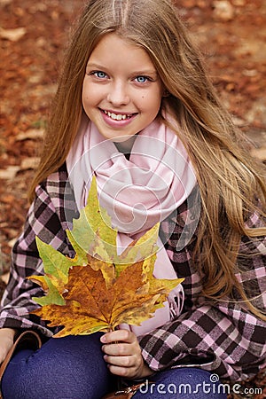 Cute smiling girl with maple leaves in hands Stock Photo