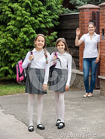 Cute smiling girls leaving home for school at morning Stock Photo