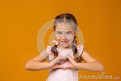Cute smiling little child girl making heart-shape gesture Stock Photo