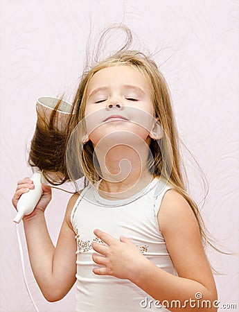 Cute smiling Little girl dries hair Stock Photo