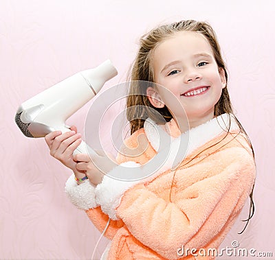 Cute smiling little girl dries hair Stock Photo
