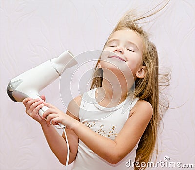 Cute smiling Little girl dries hair Stock Photo