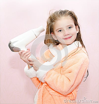 Cute smiling little girl dries hair Stock Photo