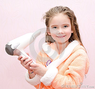 Cute smiling little girl dries hair Stock Photo