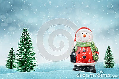 Cute snowman in Santa Claus clothes. Christmas trees beside Stock Photo