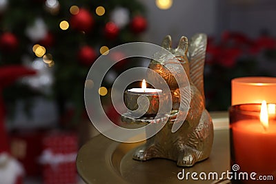 Cute squirrel shaped candle holder on table in room decorated for Christmas, space for text Stock Photo