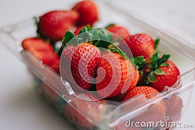 Cute strawberries in a plastic basket on a white background Stock Photo