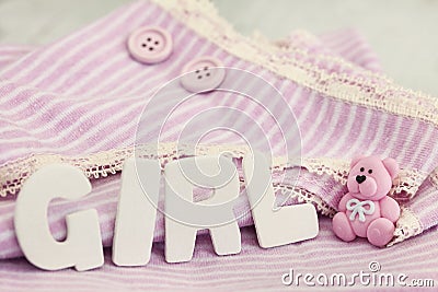 Cute striped baby shirt in the background in soft pastel pink and word girl Stock Photo