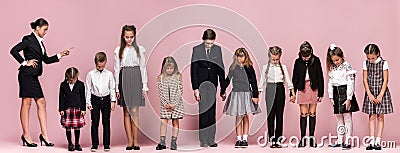 Cute stylish children on pink studio background. The beautiful teen girls and boy standing together Stock Photo