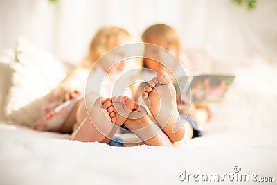Cute sweet toddler children, tickling feet on the bed, laughing and smiling Stock Photo