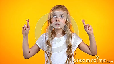 Cute teenage girl crossing fingers and looking up, superstitious belief in luck Stock Photo